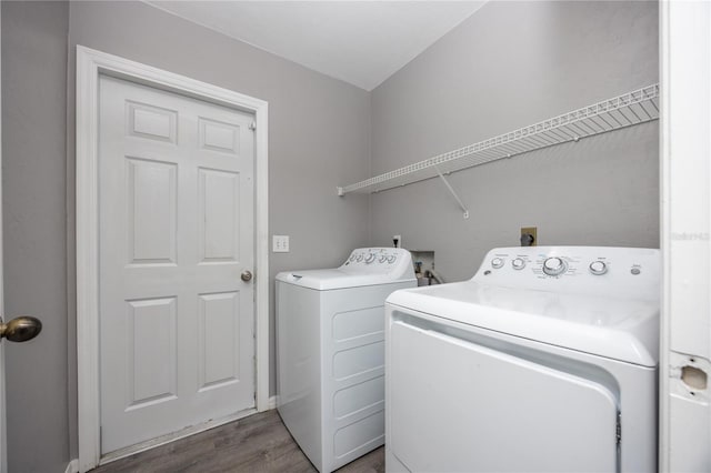 washroom featuring washer and dryer, laundry area, and dark wood finished floors