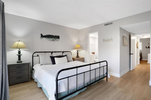 bedroom featuring light wood-style flooring, connected bathroom, visible vents, and baseboards