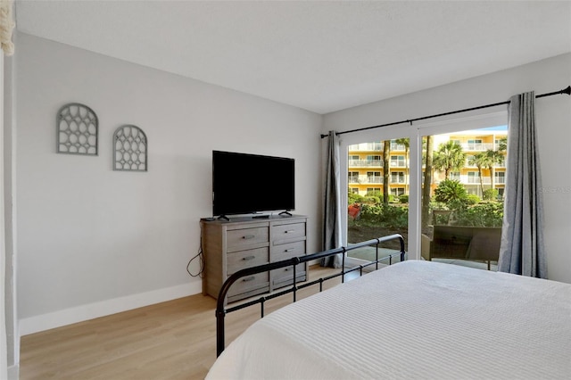 bedroom with light wood finished floors and baseboards