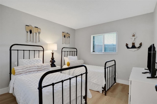 bedroom with light wood-style floors and baseboards