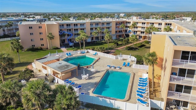 community pool with a patio area and a fenced backyard