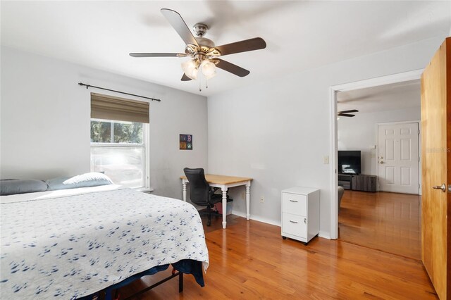 bedroom with wood finished floors, a ceiling fan, and baseboards