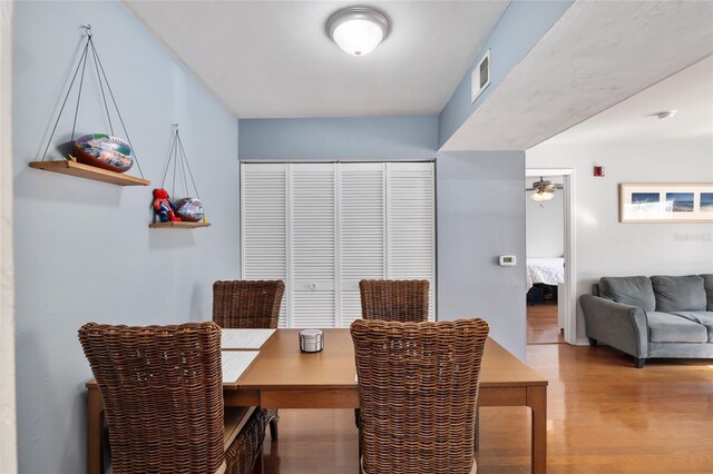 dining space featuring light wood-style flooring, visible vents, and ceiling fan