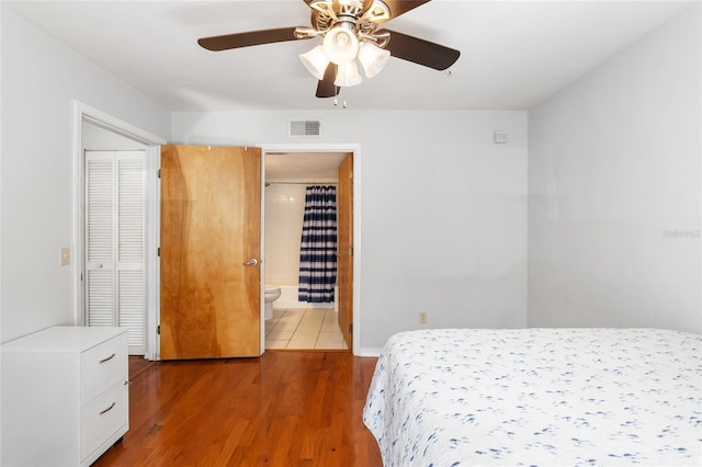 bedroom with light wood finished floors, visible vents, connected bathroom, ceiling fan, and baseboards