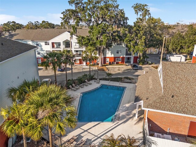 view of swimming pool featuring a residential view, fence, and a patio