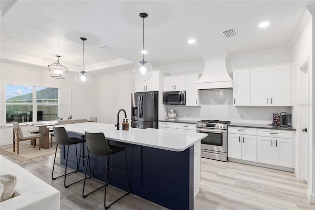 kitchen featuring stainless steel appliances, white cabinets, decorative light fixtures, and custom exhaust hood