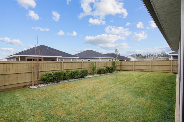 view of yard featuring a fenced backyard and a residential view