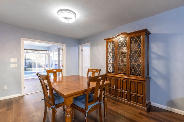 dining room with baseboards and dark wood-style flooring