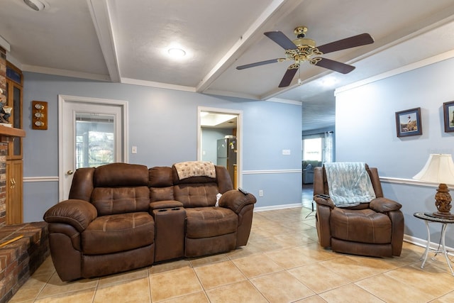 living room with light tile patterned floors, a ceiling fan, a brick fireplace, beamed ceiling, and baseboards