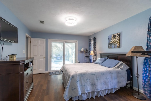 bedroom with baseboards, dark wood-type flooring, visible vents, and access to exterior