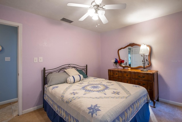 bedroom with light carpet, ceiling fan, visible vents, and baseboards