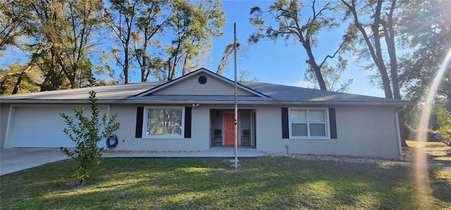 ranch-style home with a garage, a front yard, concrete driveway, and stucco siding