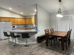 dining area with lofted ceiling, wood finished floors, and recessed lighting