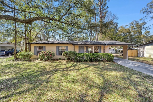 single story home featuring driveway, fence, an attached carport, and a front yard