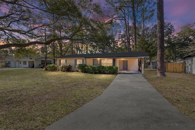 view of front of home featuring a yard, fence, and driveway