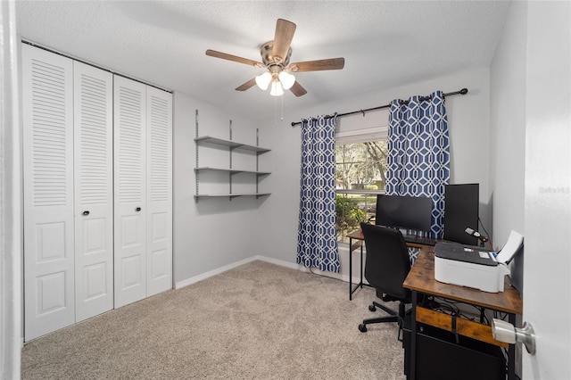 home office featuring a ceiling fan, carpet, a textured ceiling, and baseboards