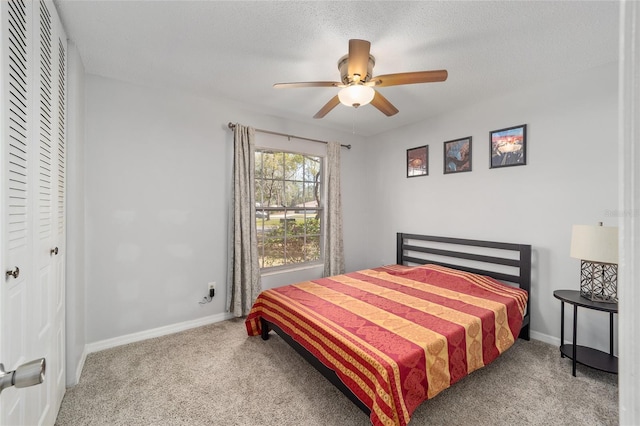 bedroom featuring a textured ceiling, a closet, carpet, and baseboards