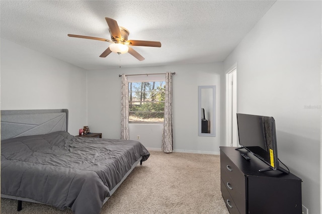 bedroom featuring a ceiling fan, light colored carpet, a textured ceiling, and baseboards