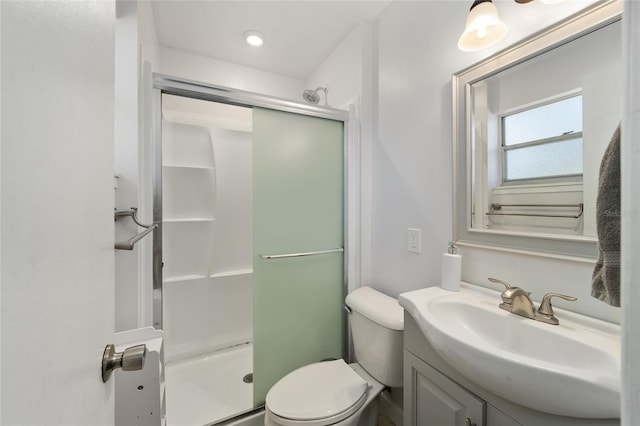 bathroom with toilet, a shower stall, and vanity