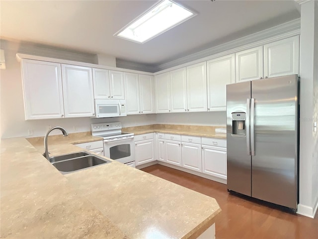 kitchen featuring a peninsula, white appliances, a sink, white cabinets, and light countertops