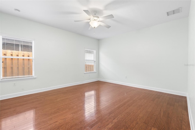 empty room with visible vents, baseboards, and wood finished floors