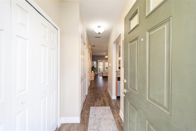 corridor with dark wood finished floors and baseboards