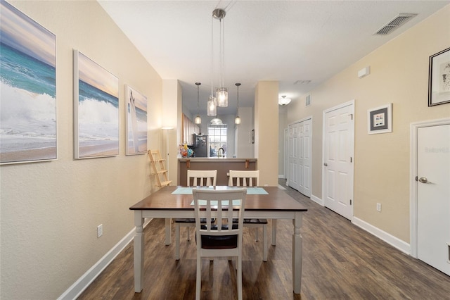 dining room featuring baseboards, visible vents, and wood finished floors