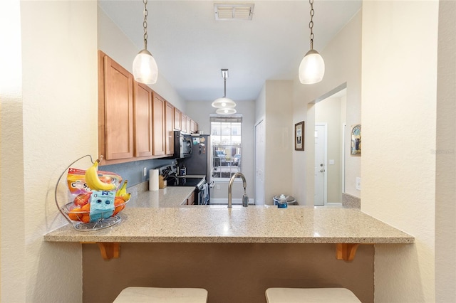 kitchen with black microwave, a peninsula, visible vents, stainless steel range with electric cooktop, and light stone countertops