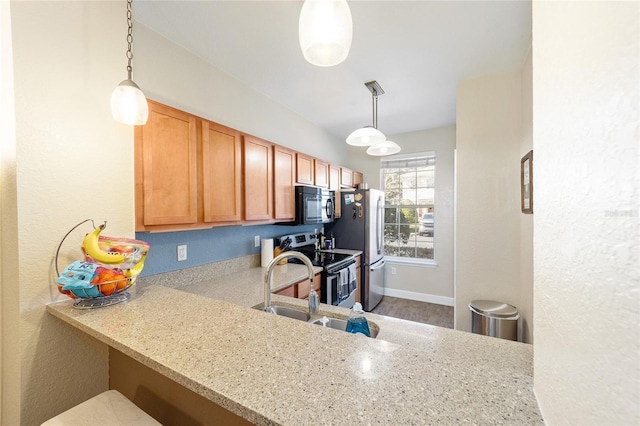 kitchen featuring stainless steel appliances, a sink, hanging light fixtures, and light stone countertops