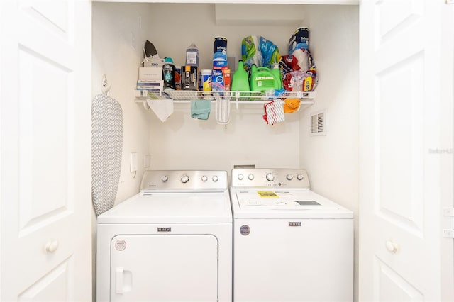 washroom featuring laundry area, washing machine and dryer, and visible vents