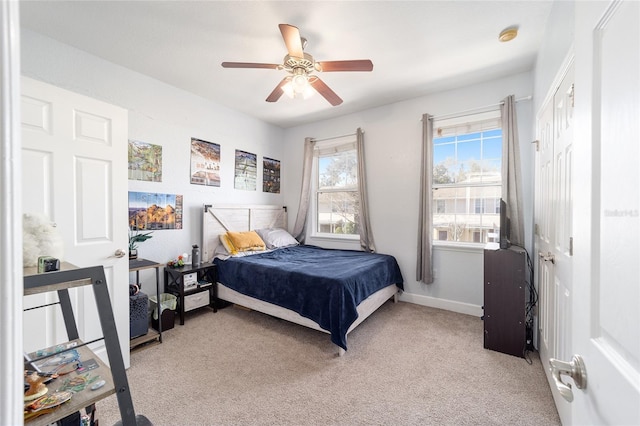 bedroom with light carpet, ceiling fan, and baseboards