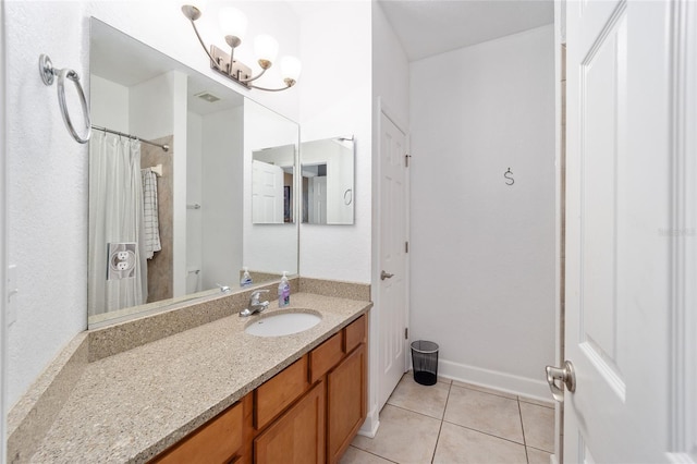 bathroom with tile patterned flooring, baseboards, and vanity