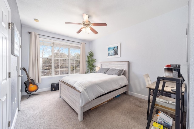 bedroom with a ceiling fan, light carpet, and baseboards