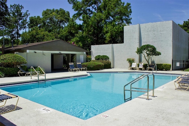 pool with fence and a patio