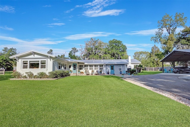 ranch-style home featuring driveway, fence, and a front yard