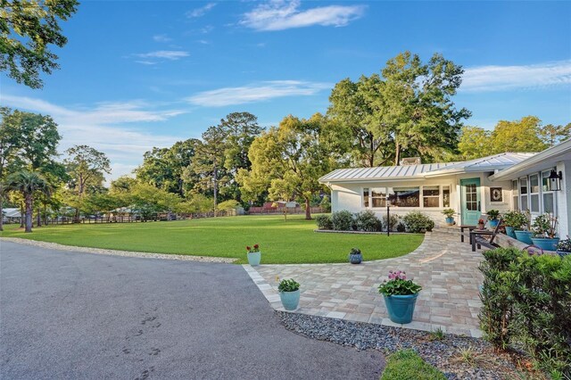 view of community featuring a lawn and fence