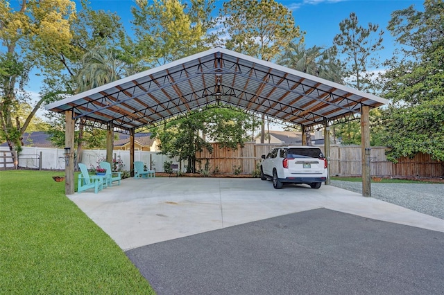 view of car parking featuring a detached carport, driveway, and fence