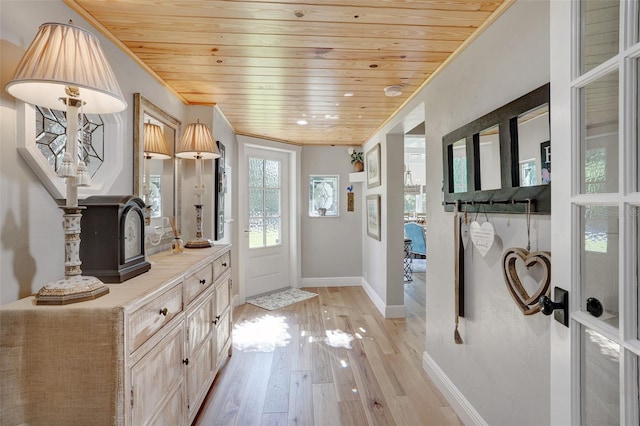 doorway to outside with ornamental molding, light wood-type flooring, wood ceiling, and baseboards