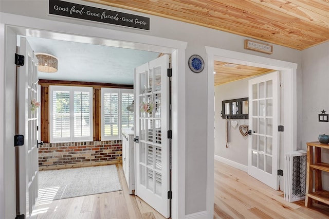 interior space with brick wall, french doors, wood finished floors, and wood ceiling