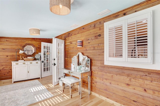 interior space featuring wood walls, wood finished floors, and visible vents