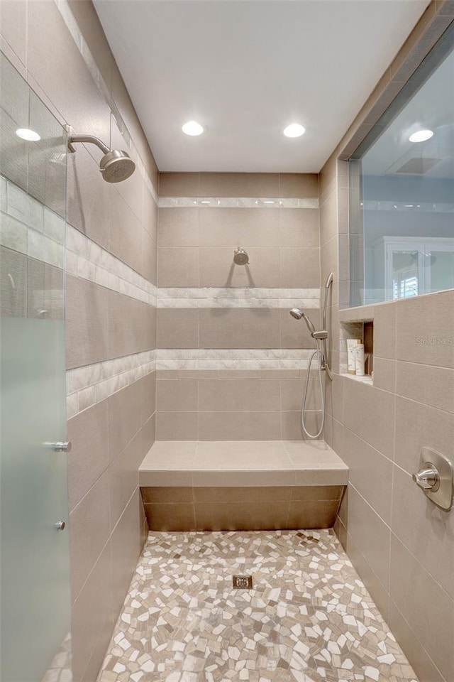 bathroom with tiled shower and recessed lighting