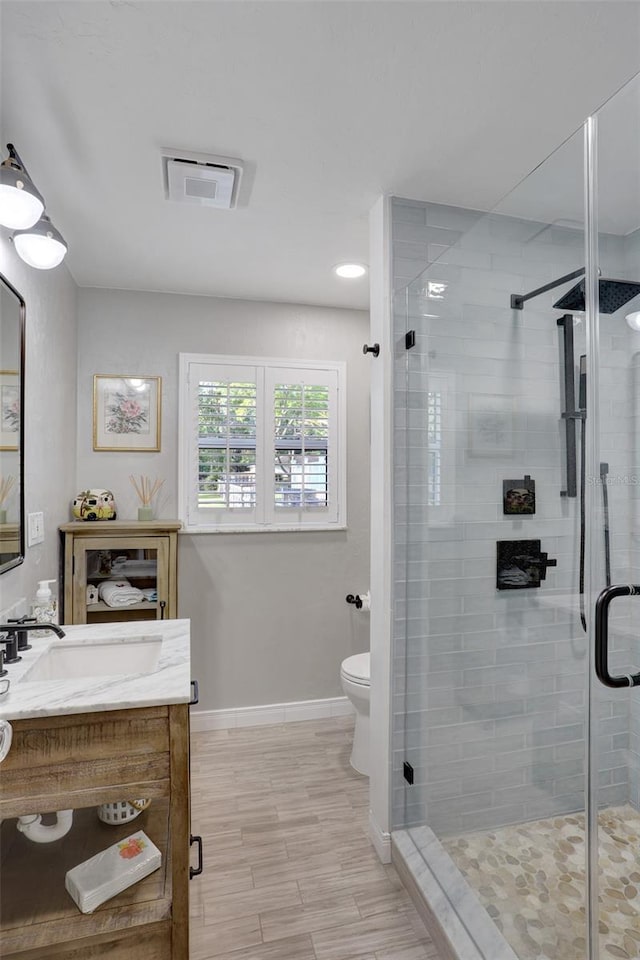 full bathroom featuring baseboards, vanity, visible vents, and a shower stall