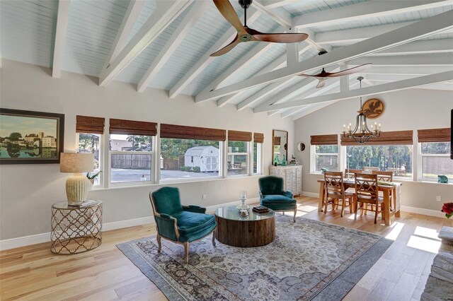 sunroom featuring vaulted ceiling with beams and ceiling fan with notable chandelier