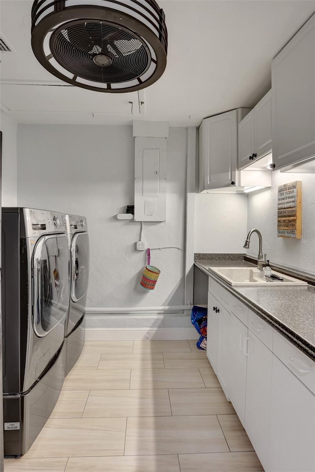 washroom featuring electric panel, baseboards, a sink, and washing machine and clothes dryer