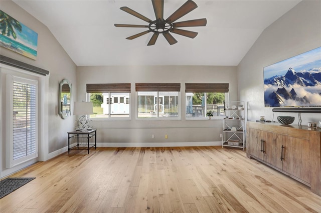 living area featuring vaulted ceiling, light wood finished floors, and a wealth of natural light