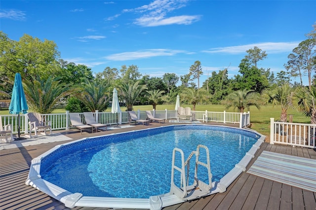 outdoor pool featuring a patio area, fence, and a wooden deck