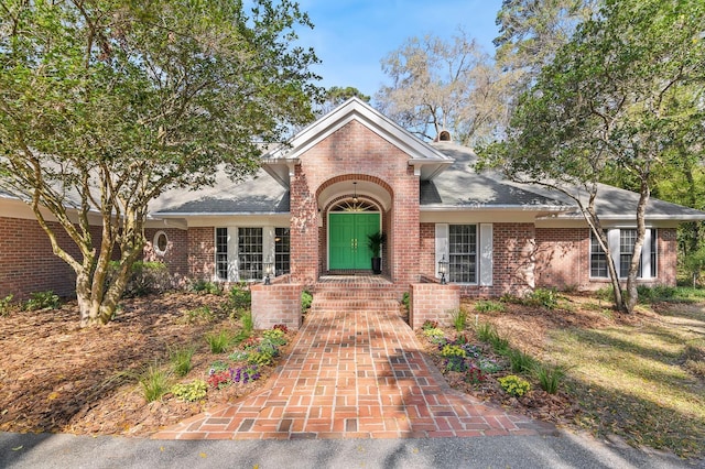 view of front of home featuring brick siding and a chimney