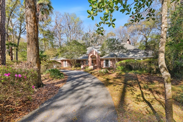 view of front of property featuring aphalt driveway and a chimney