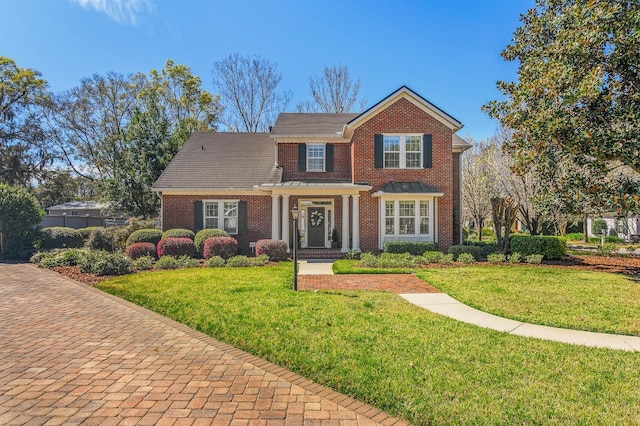 view of front of home featuring brick siding and a front yard