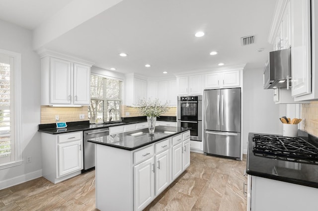 kitchen featuring dark countertops, white cabinets, visible vents, and stainless steel appliances